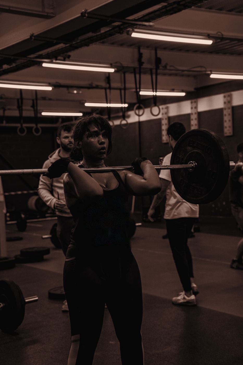 Athlète noire qui soulève une barre en salle