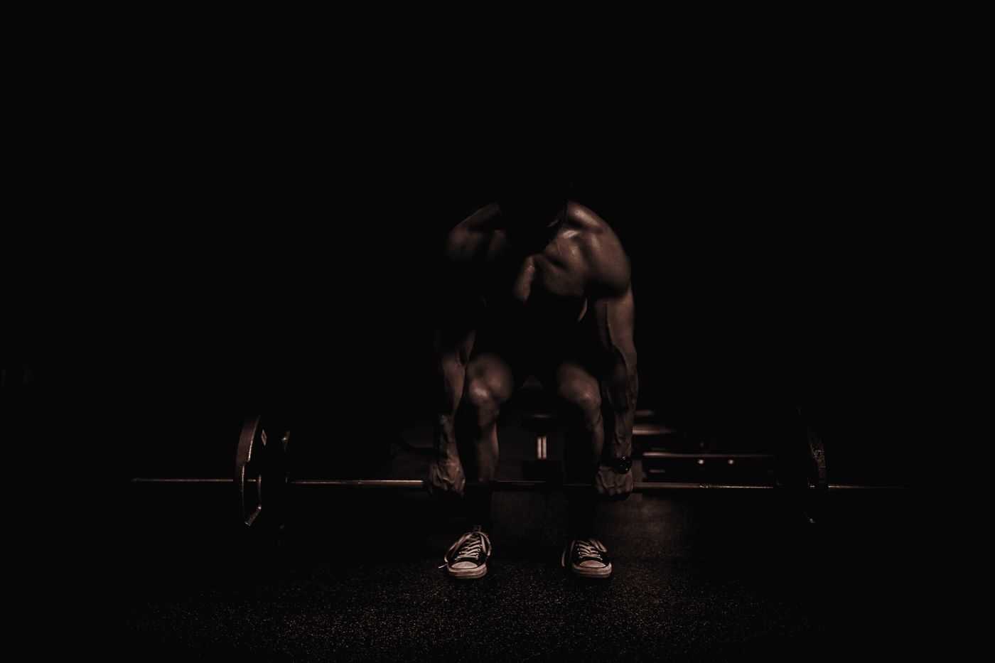 Athlète qui soulève une barre dans l'obscurité